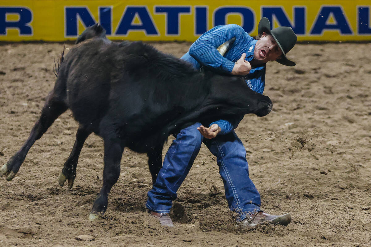 Nick Guy wrestles the steer during day three of the National Finals Rodeo at the Thomas & M ...