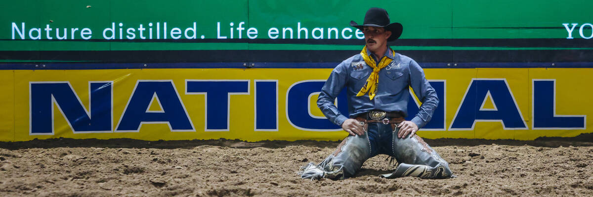 Tanner Butner sits in the dirt after his saddle bronc ride during day three of the National Fin ...