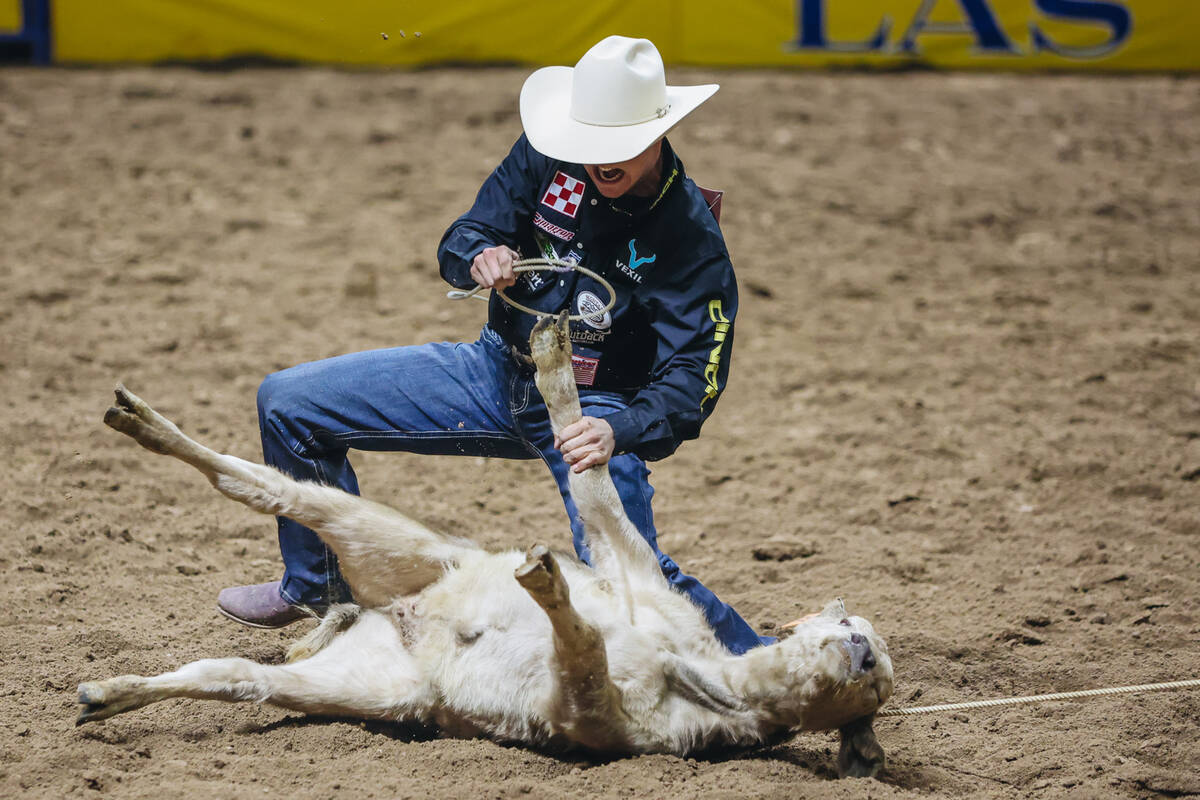 Kincade Henry ties up the calf during tie down roping on day three of the National Finals Rodeo ...