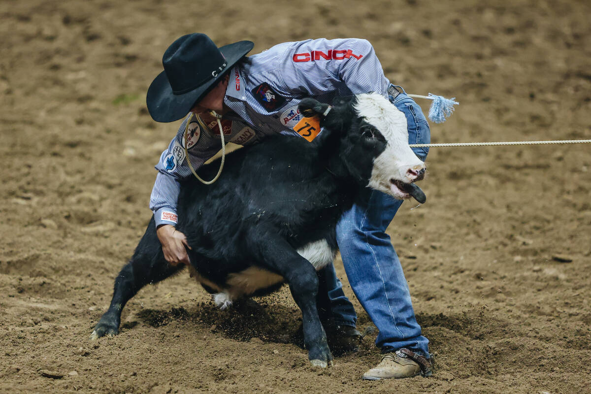 Westin Hughes picks up the calf during tie down roping during day three of the National Finals ...