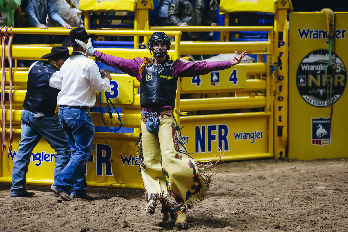 Jared Parsonage celebrates his bull ride during day three of the National Finals Rodeo at the T ...