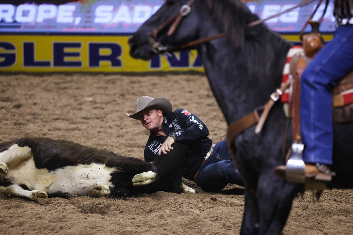 Dakota Eldridge looks up to see his time after wrestling a steer to the ground while he compete ...