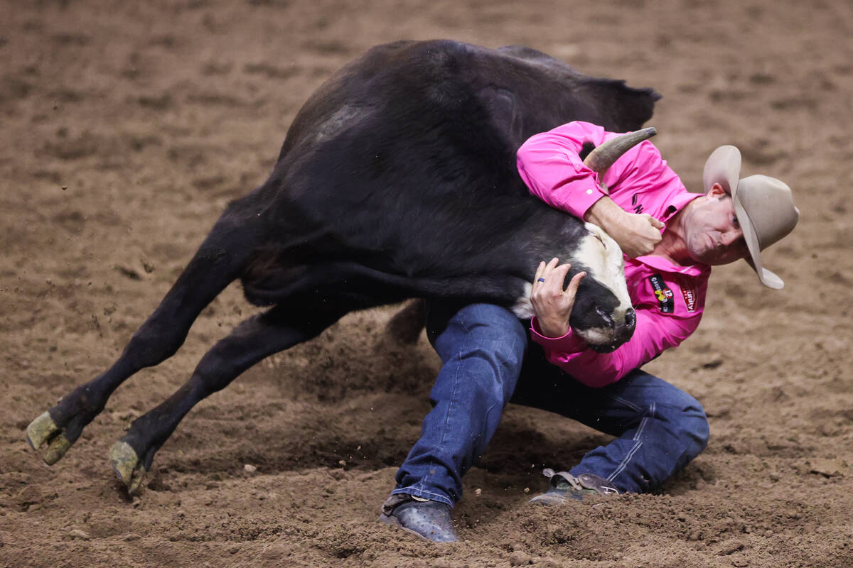 Tyler Waguespack wrestles a steer to the ground while he competes in steer wrestling on day fou ...