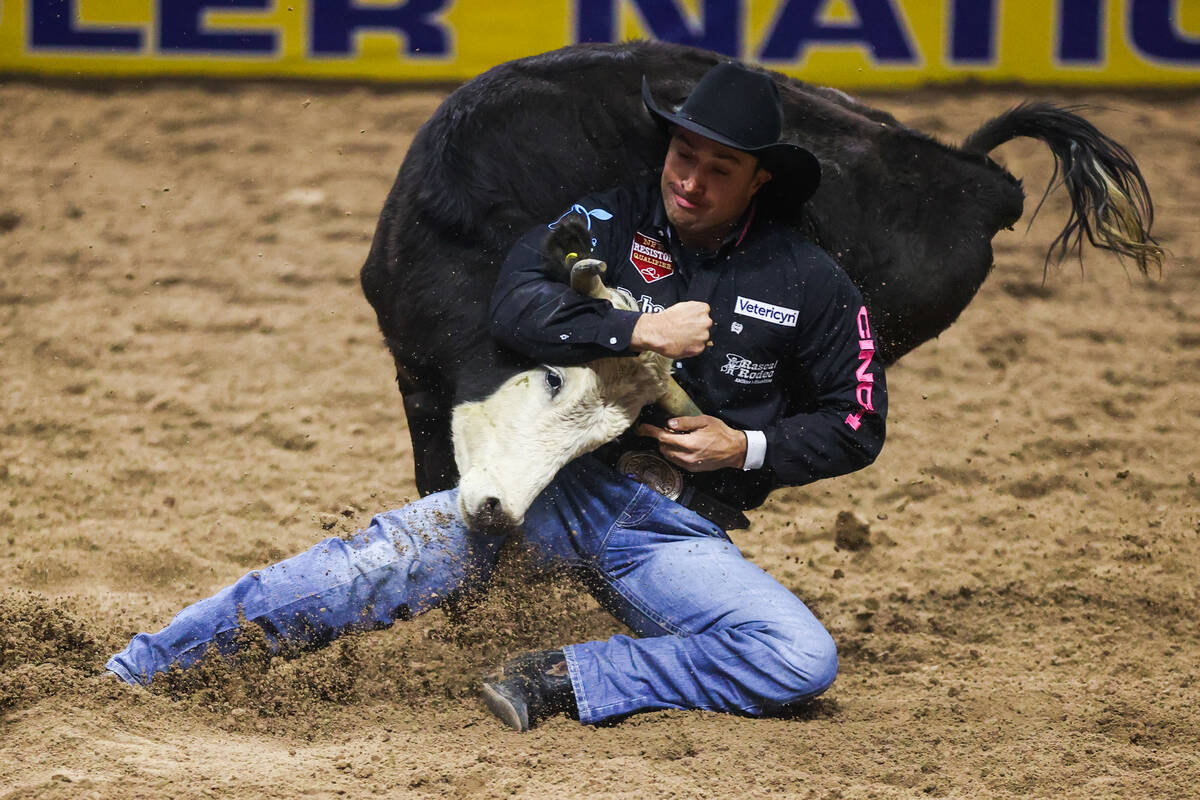 Jesse Brown wrestle a steer to the ground while he competes in steer wrestling on day four of t ...