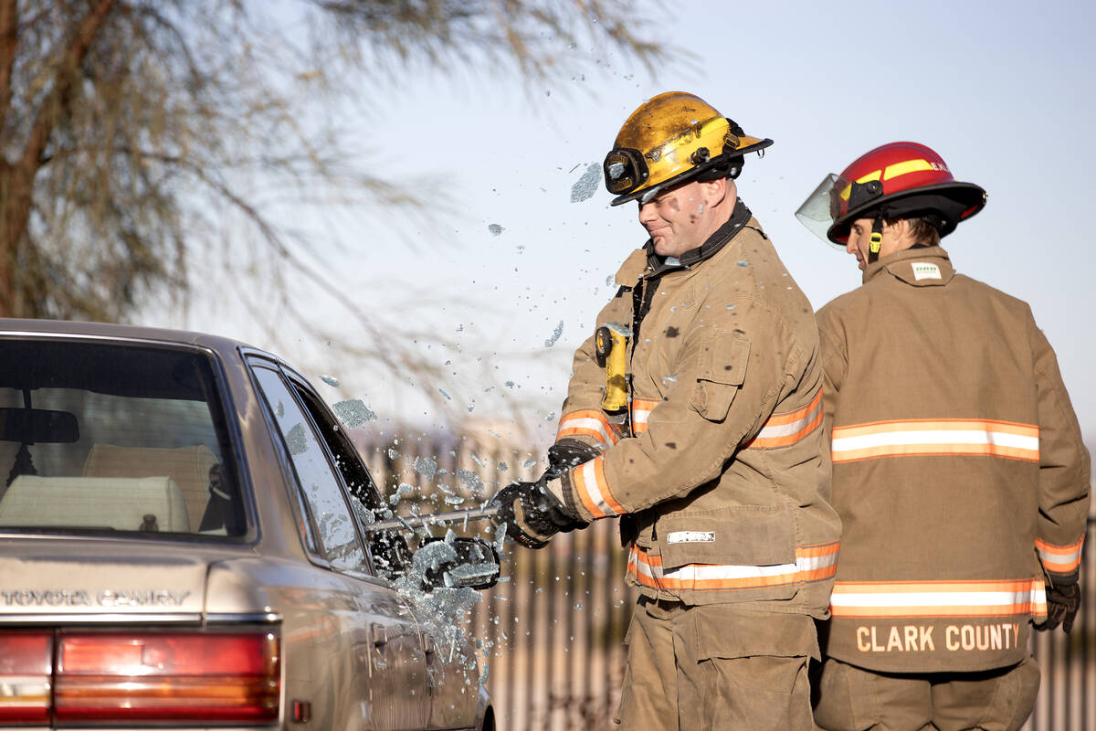 Firefighter paramedic Matthew Lemieux smashes a car window during a model extraction during a c ...