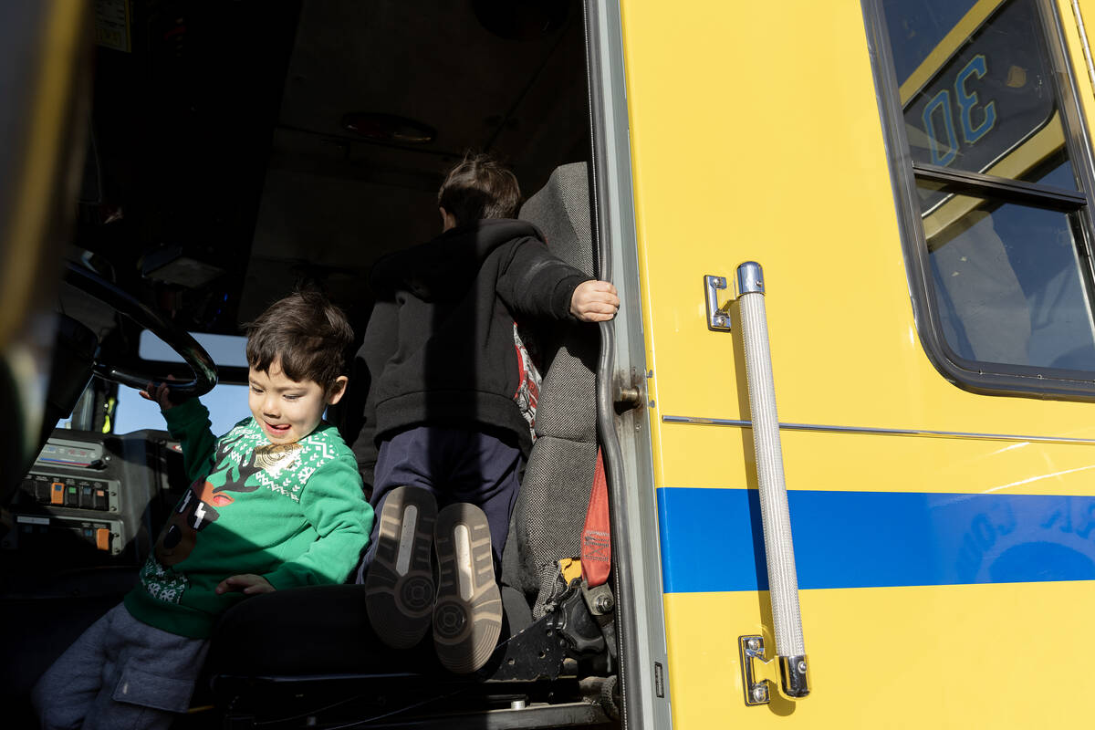 Decklan Ono, 3, left, explores a firetruck with his brother Pace Ono, 5, during a community eve ...