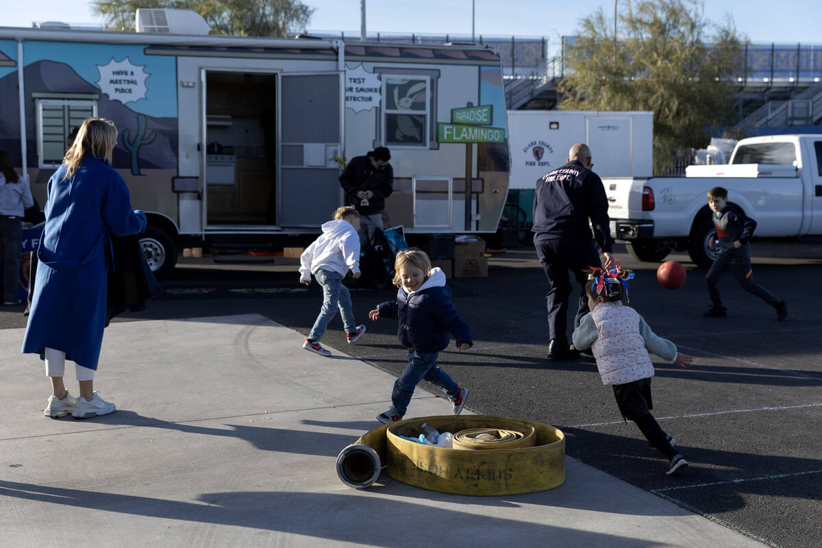 Little ones run around a fire hose during a community event put on by the Clark County Fire Dep ...