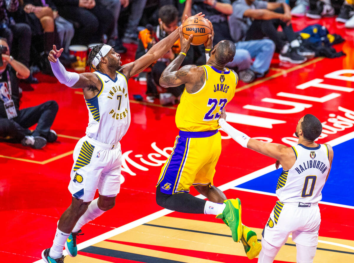 Los Angeles Lakers forward LeBron James (23) soars to the basket for a score between Indiana Pa ...