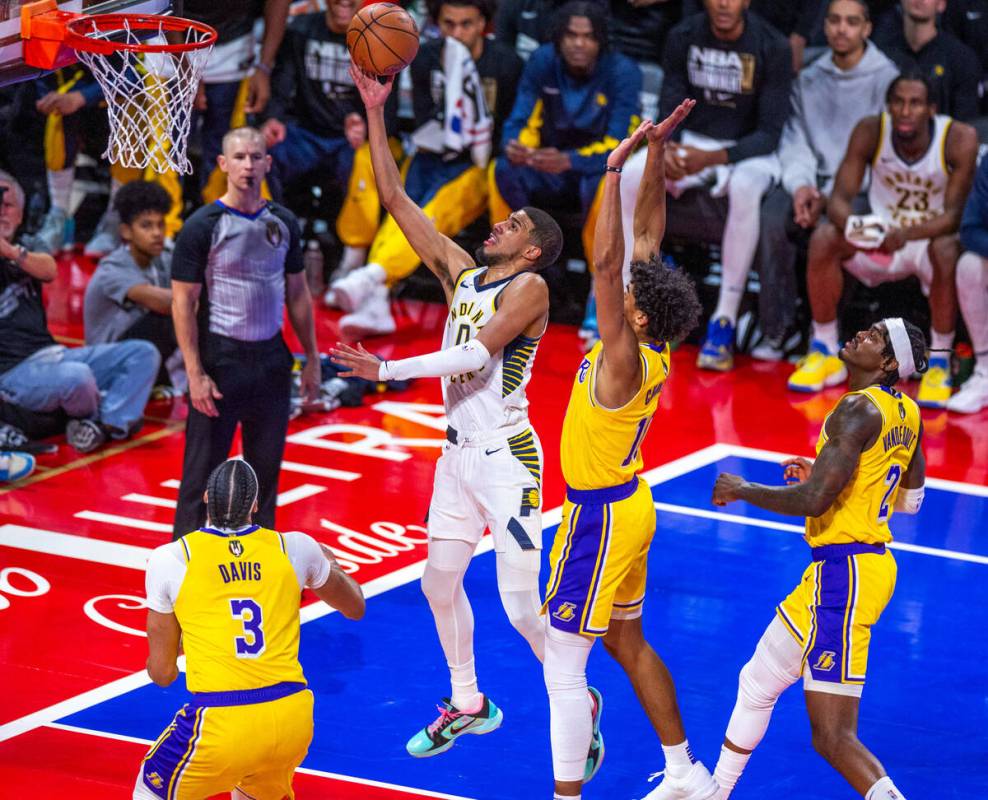 Indiana Pacers guard Tyrese Haliburton (0) scores over Los Angeles Lakers guard Max Christie (1 ...