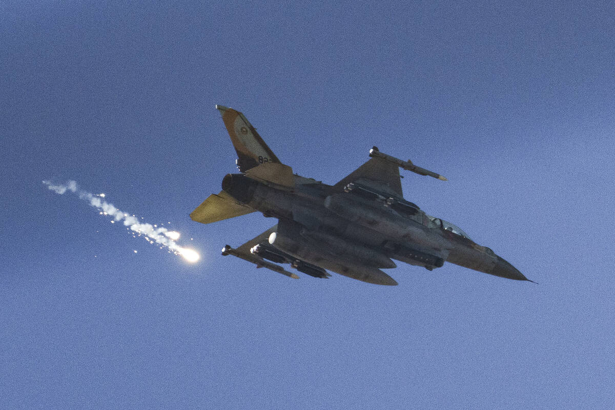 An Israeli fighter jet releases flares as it flies over the Gaza Strip, as seen from southern I ...