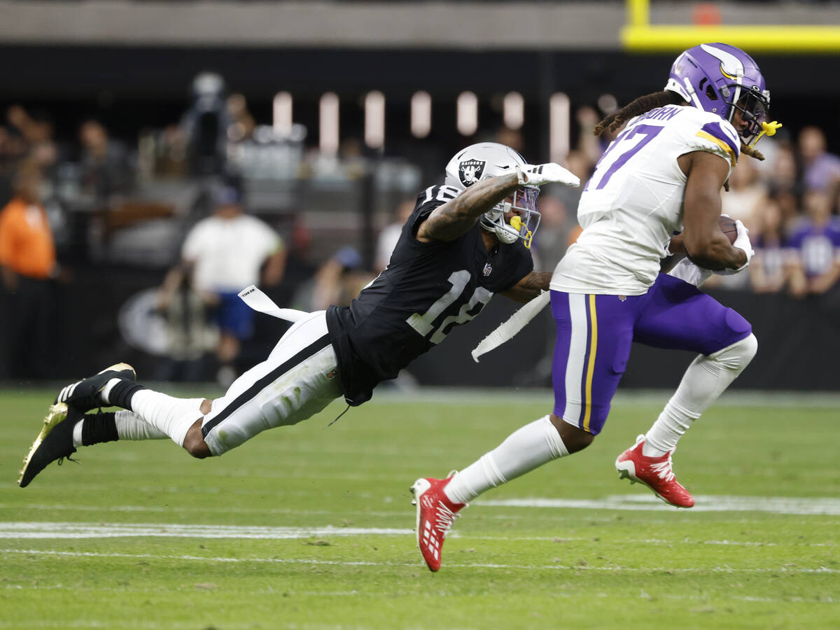 Raiders cornerback Jack Jones (18) dives to take down Minnesota Vikings wide receiver K.J. Osbo ...