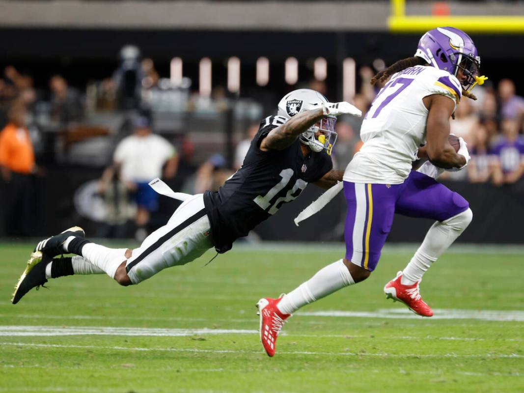 Raiders cornerback Jack Jones (18) dives to take down Minnesota Vikings wide receiver K.J. Osbo ...