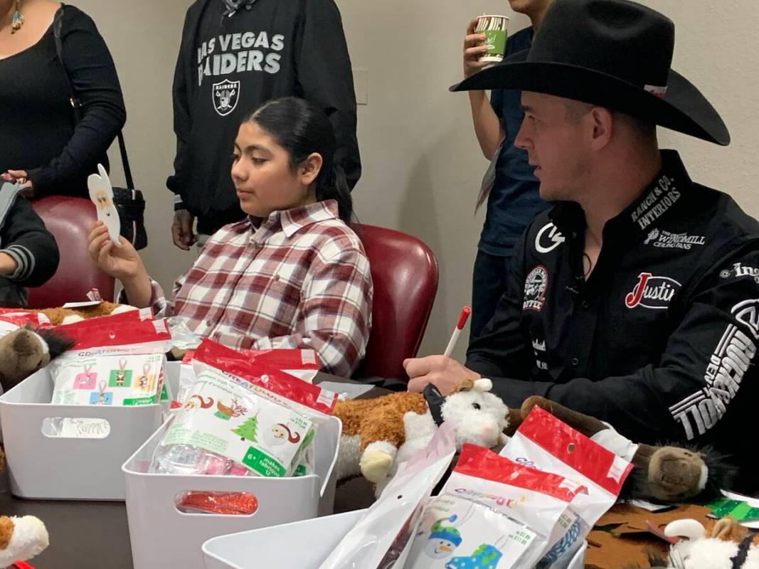 Tim O'Connell looks on with approval at Amado Escoto's holiday project during the Wrangler NFR' ...