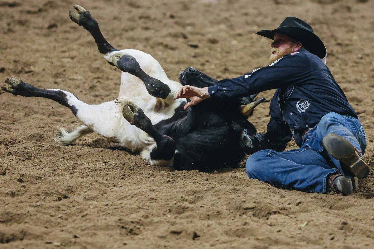 Will Lummus wrestles the steer during steer wrestling on day three of the National Finals Rodeo ...