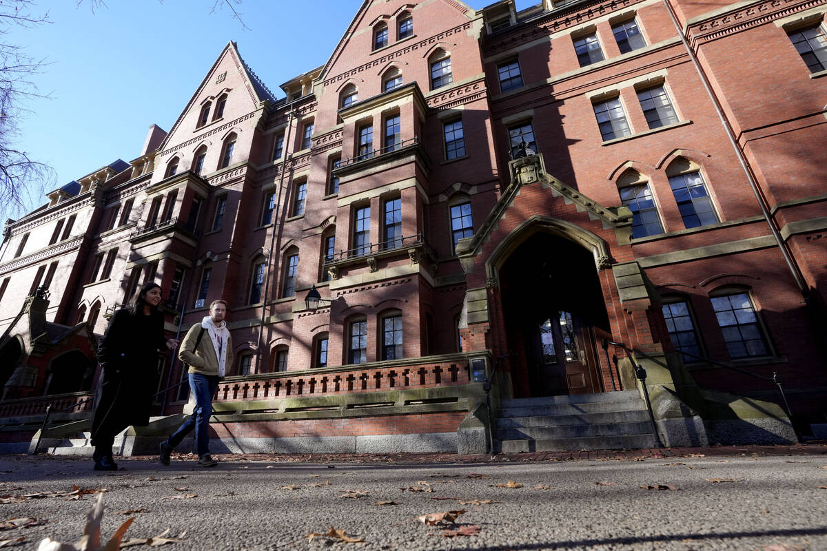 Passers-by walk walk on the campus of Harvard University, Tuesday, Dec. 12, 2023, in Cambridge, ...