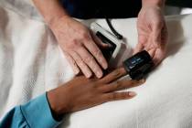 FILE - A nurse checks the vitals of a 33-year-old woman in Shreveport, La., on Oct. 9, 2021. A ...