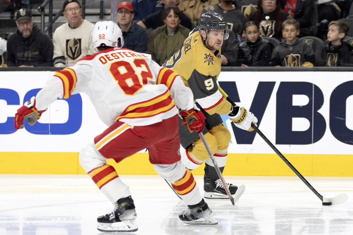 Golden Knights center Jack Eichel (9) takes the puck up the ice against Flames defenseman Jorda ...