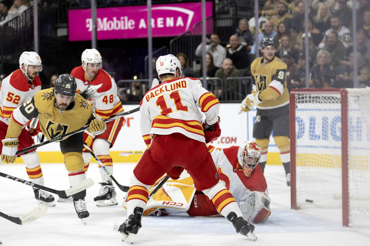 Golden Knights center Chandler Stephenson (20) scores a goal on Flames goaltender Dustin Wolf ( ...