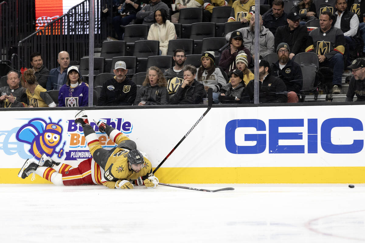 Golden Knights right wing Michael Amadio (22) tumbles over Flames defenseman MacKenzie Weegar ( ...