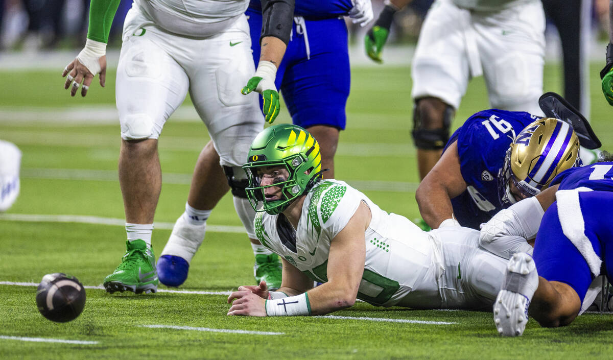 Oregon Ducks quarterback Bo Nix (10) looks to a loose ball on a run after a tackle by Washingto ...