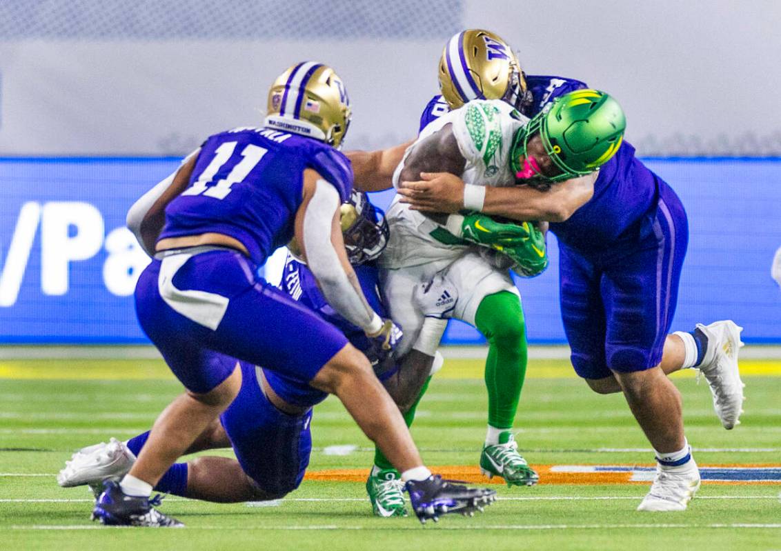 Oregon Ducks wide receiver Kris Hutson (1) is taken down by Washington Huskies linebacker Edefu ...