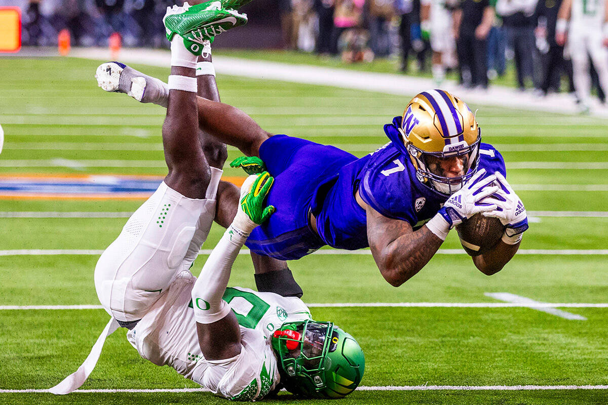 Washington Huskies running back Dillon Johnson (7) dives for the end zone as Oregon Ducks defen ...