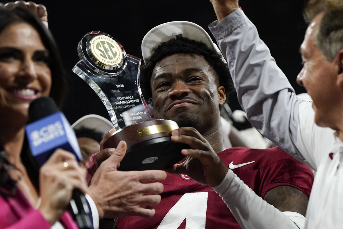 Alabama quarterback Jalen Milroe (4) holds up the most valuable player trophy after the Southea ...