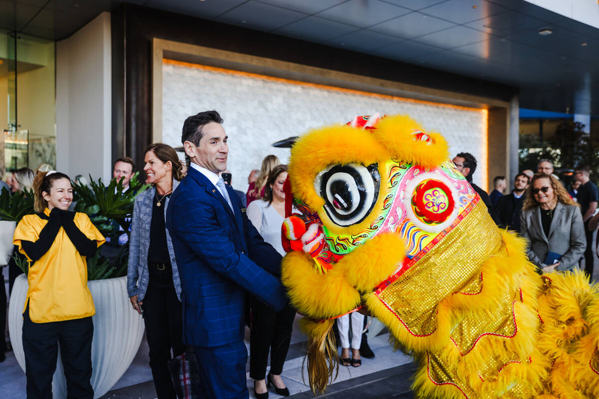 Mark Tricano, president of Fontainebleau Las Vegas, “feeds” a lion from the Lohan ...