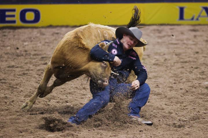 JD Struxness wrestles a steer to the ground while he competes in steer wrestling on day four of ...