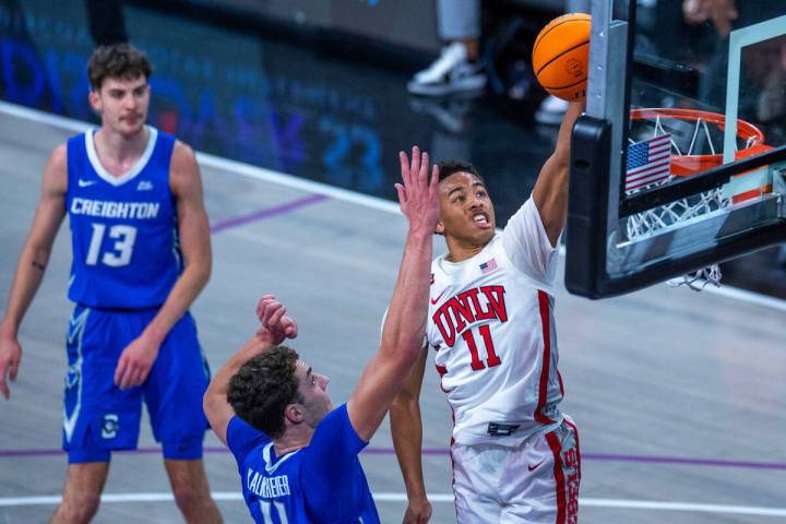 UNLV Rebels guard Dedan Thomas Jr. (11) soars to the rim above Creighton Bluejays center Ryan K ...