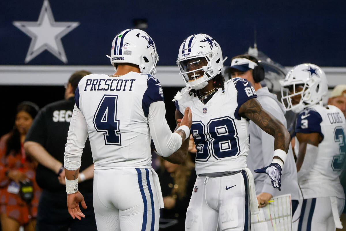 Dallas Cowboys quarterback Dak Prescott (4) and wide receiver CeeDee Lamb (88) react after conn ...