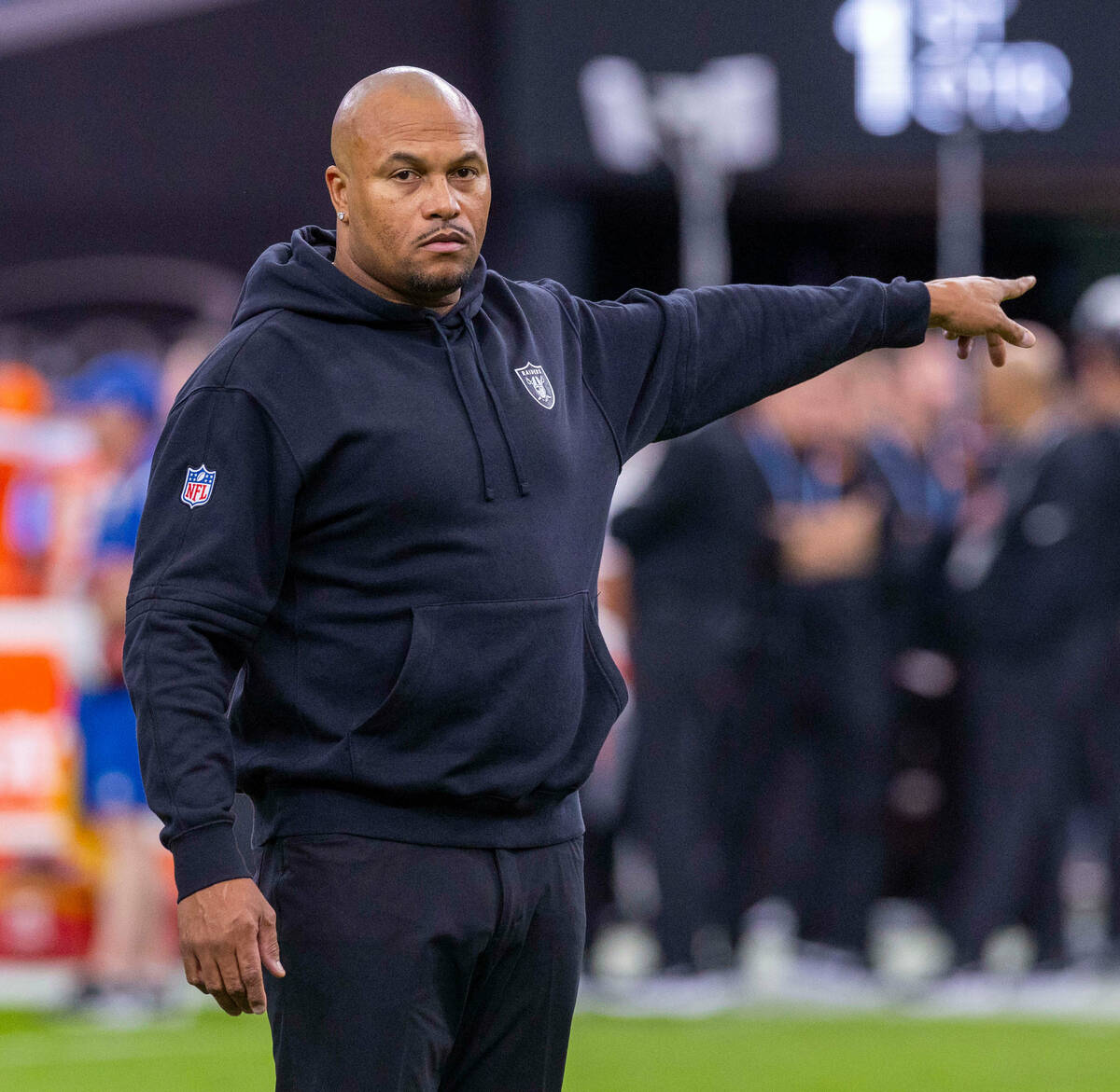 Raiders interim head coach Antonio Pierce talks with a player before the first half of their NF ...