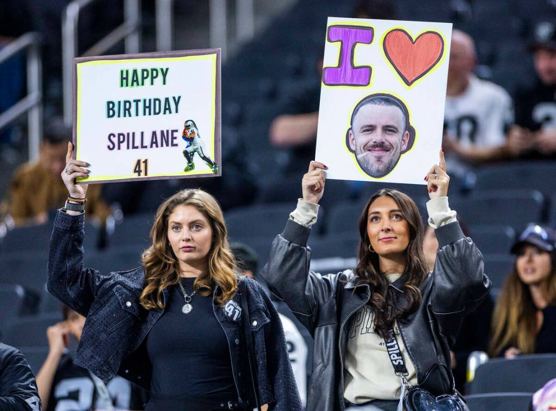 Raiders fans hold signs for Raiders linebacker Robert Spillane (41) during warmups before the f ...