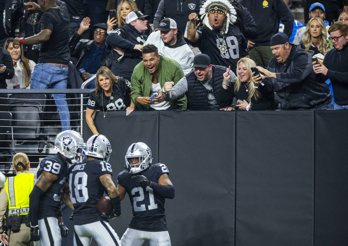 Raiders fans celebrate an interception and touchdown by cornerback Jack Jones (18) against the ...