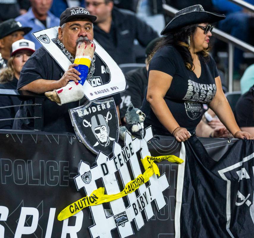 A Raiders fan chews on a fake Los Angeles Chargers leg as they dominate during the second half ...