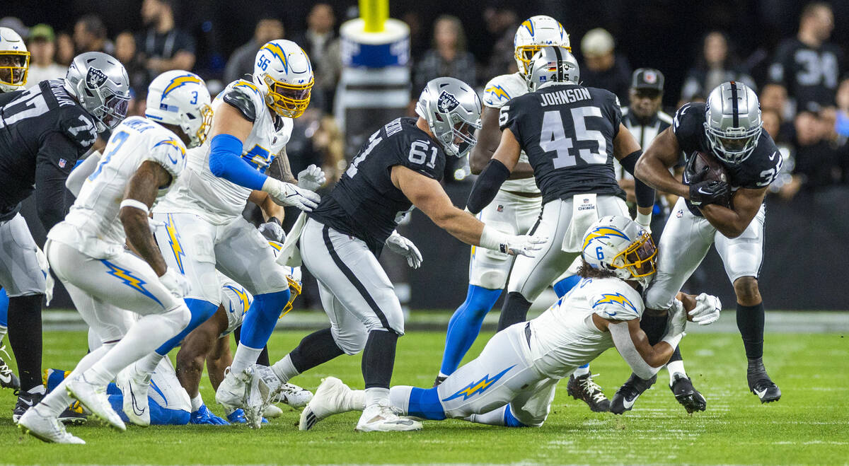 Raiders running back Zamir White (35) is tackled by Los Angeles Chargers linebacker Eric Kendri ...