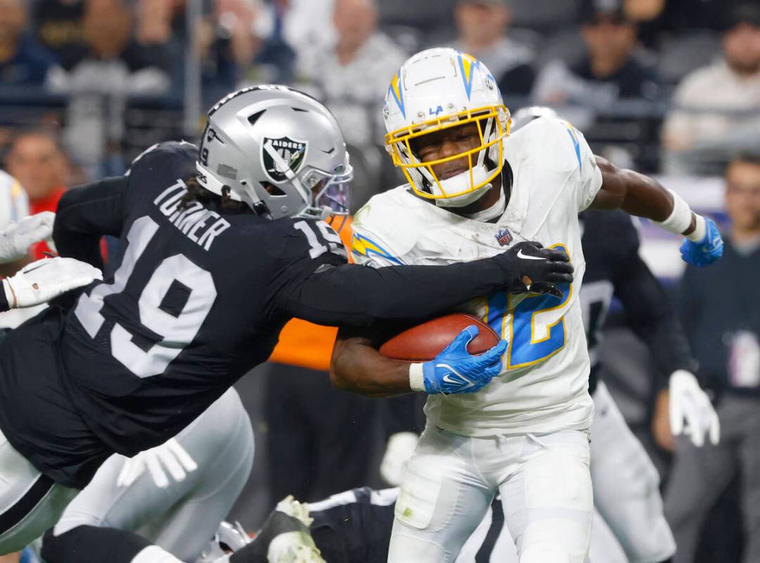 Raiders wide receiver DJ Turner (19) tackles Los Angeles Chargers wide receiver Derius Davis (1 ...