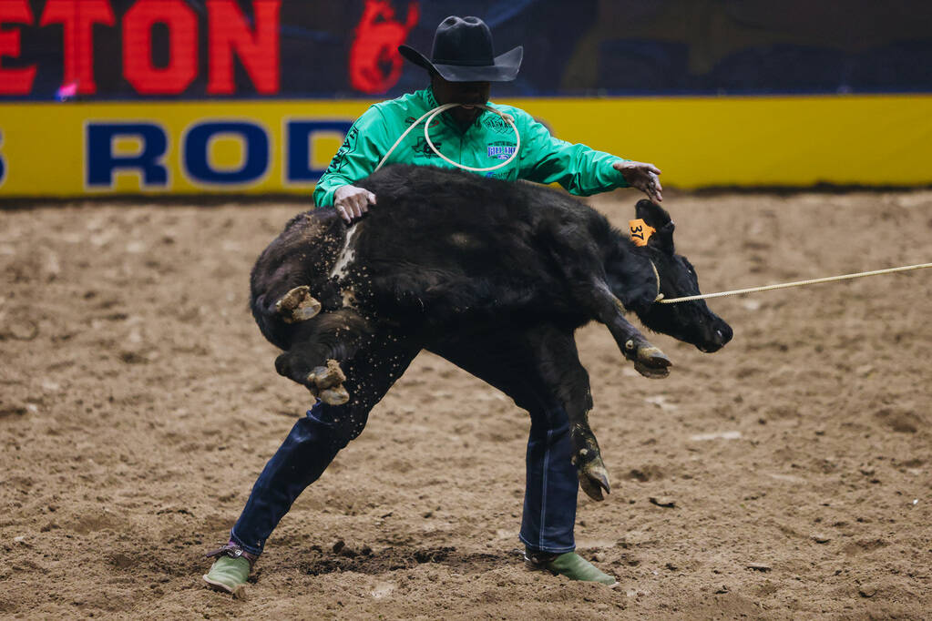 Cory Solomon picks up the calf during tie down roping at the National Finals Rodeo at the Thoma ...