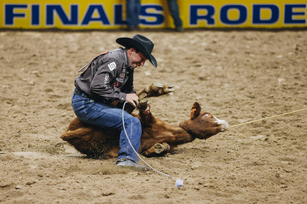Haven Meged ties the calf during tie down roping the National Finals Rodeo at the Thomas & ...