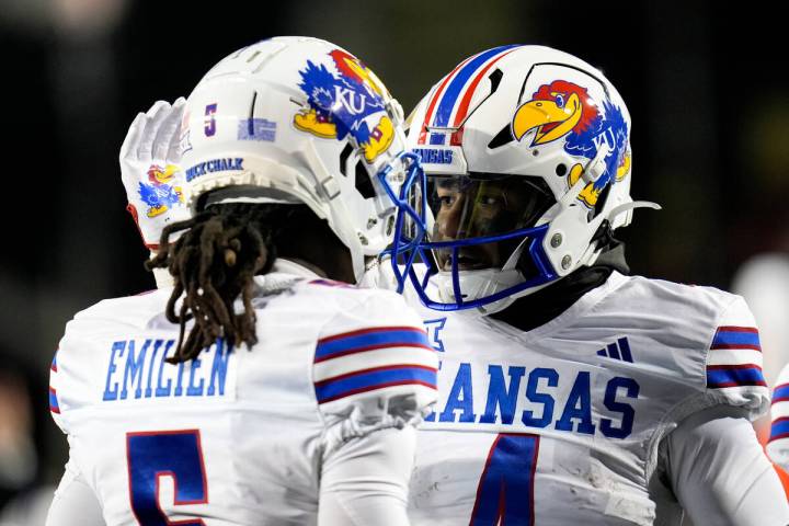 Kansas running back Devin Neal, right, pats wide receiver Doug Emilien's helmet after Neal scor ...