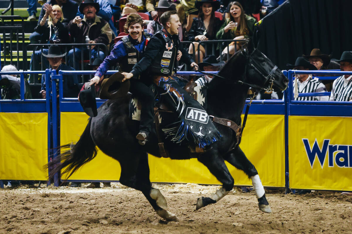 Zeke Thurston, front, and Sage Newman ride together on the same horse for a victory lap after a ...