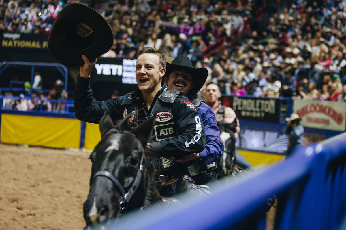 Zeke Thurston, front, and Sage Newman ride together on the same horse for a victory lap after a ...