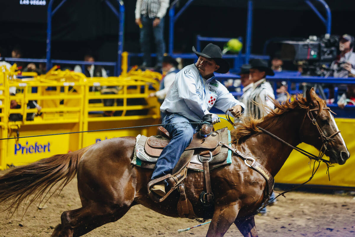 Erich Rogers ropes the neck of the calf during the National Finals Rodeo at the Thomas & Ma ...