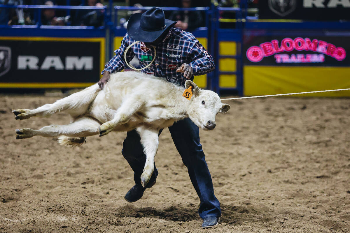 John Douch picks up the calf during tie down roping at the National Finals Rodeo at the Thomas ...