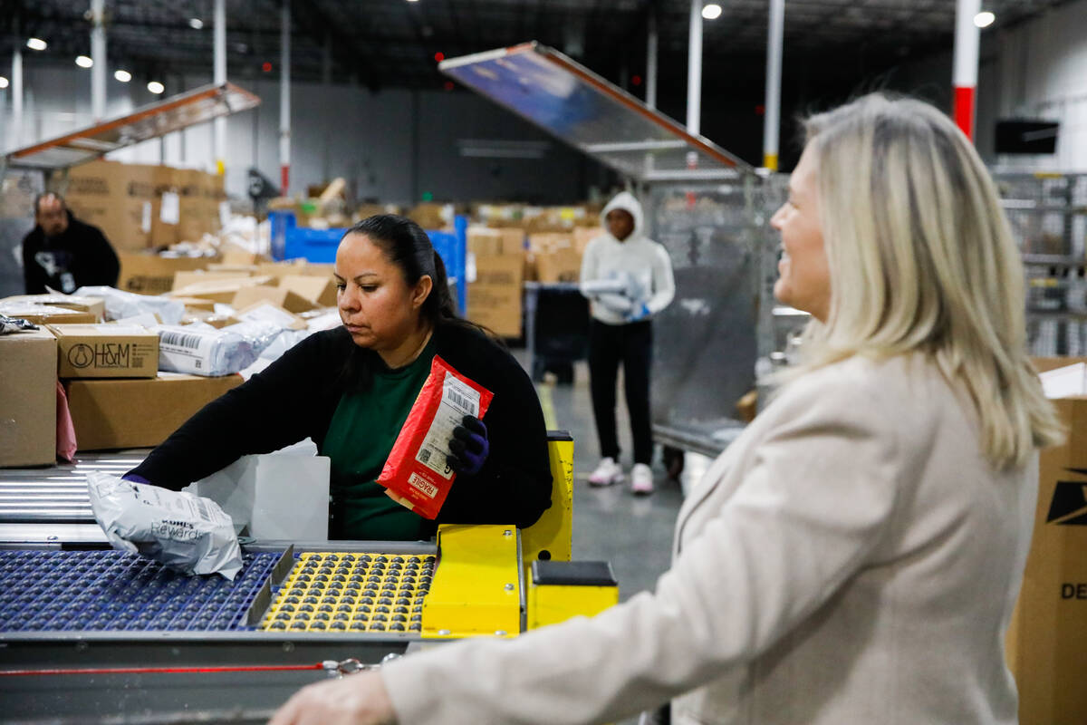 Aureoia Garcia, a USPS employee, sorts packages at a distribution center less than two weeks be ...