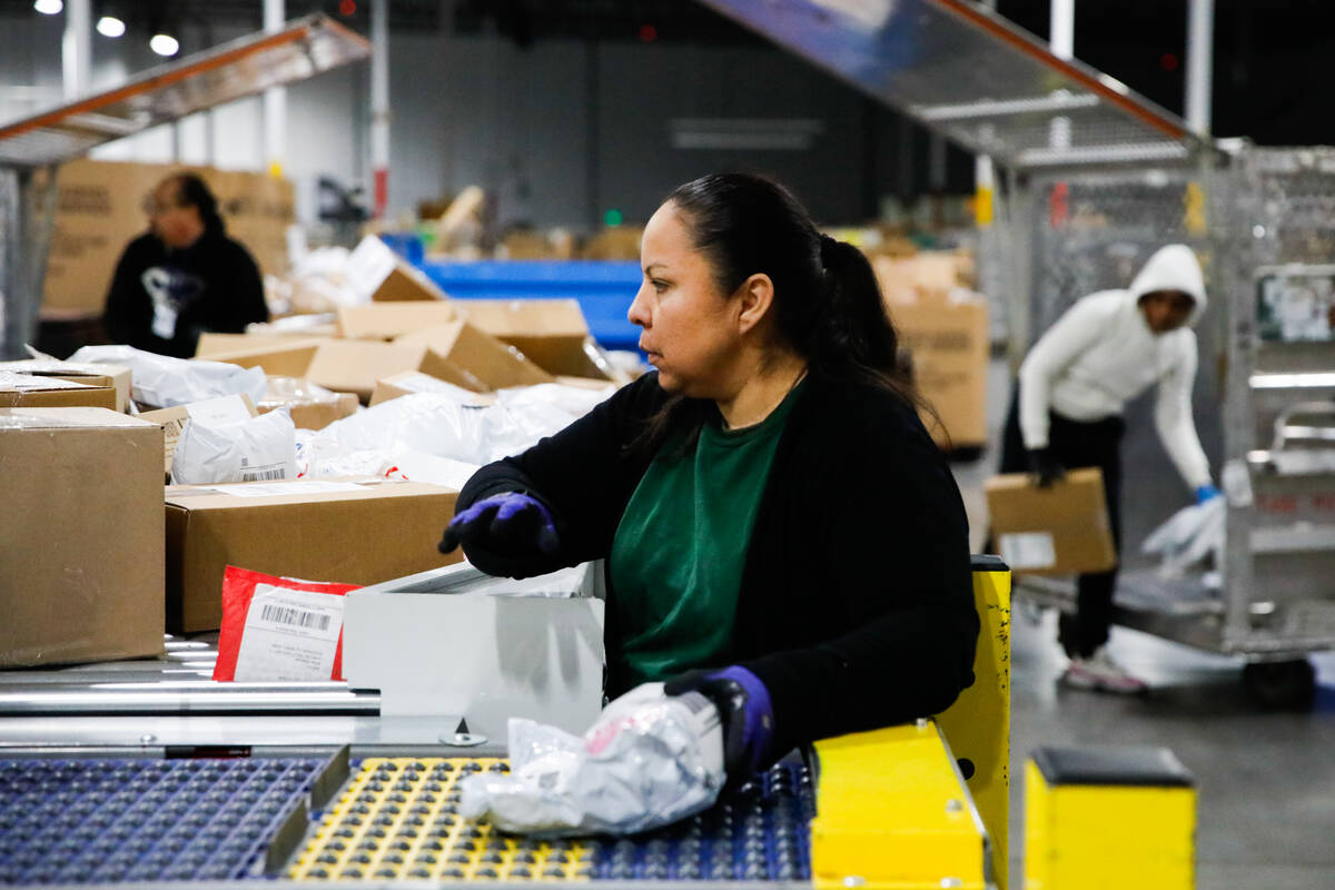 Aureoia Garcia, a USPS employee, sorts packages at a distribution center less than two weeks be ...