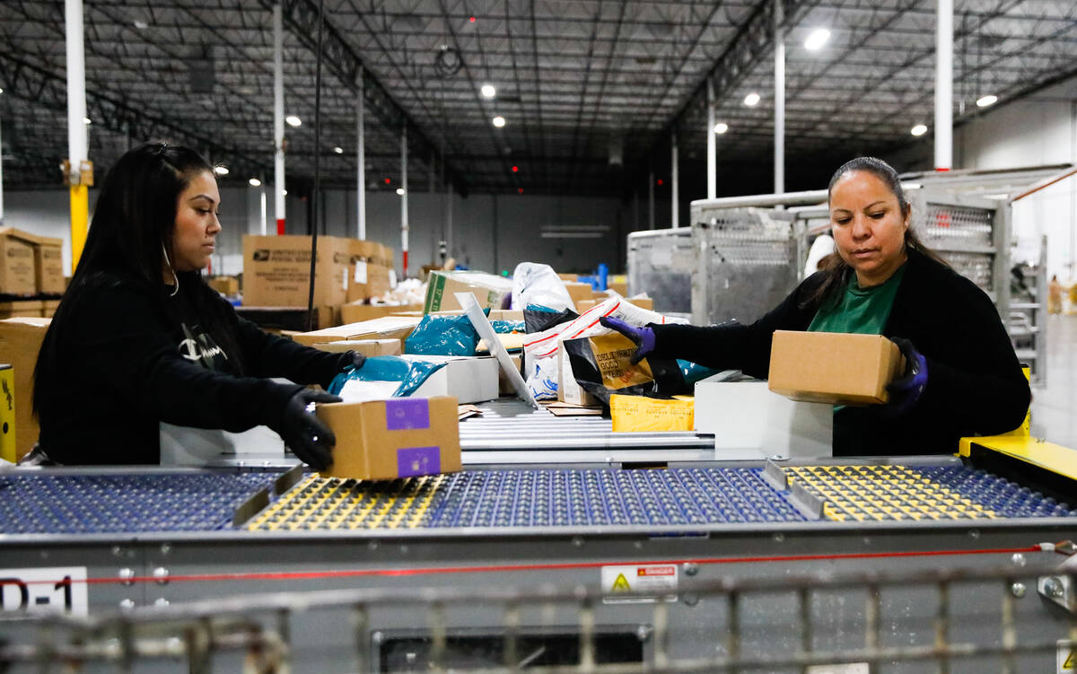 Kim Lopez, left, and Aureoia Garcia, USPS employees, sort packages at a distribution center les ...