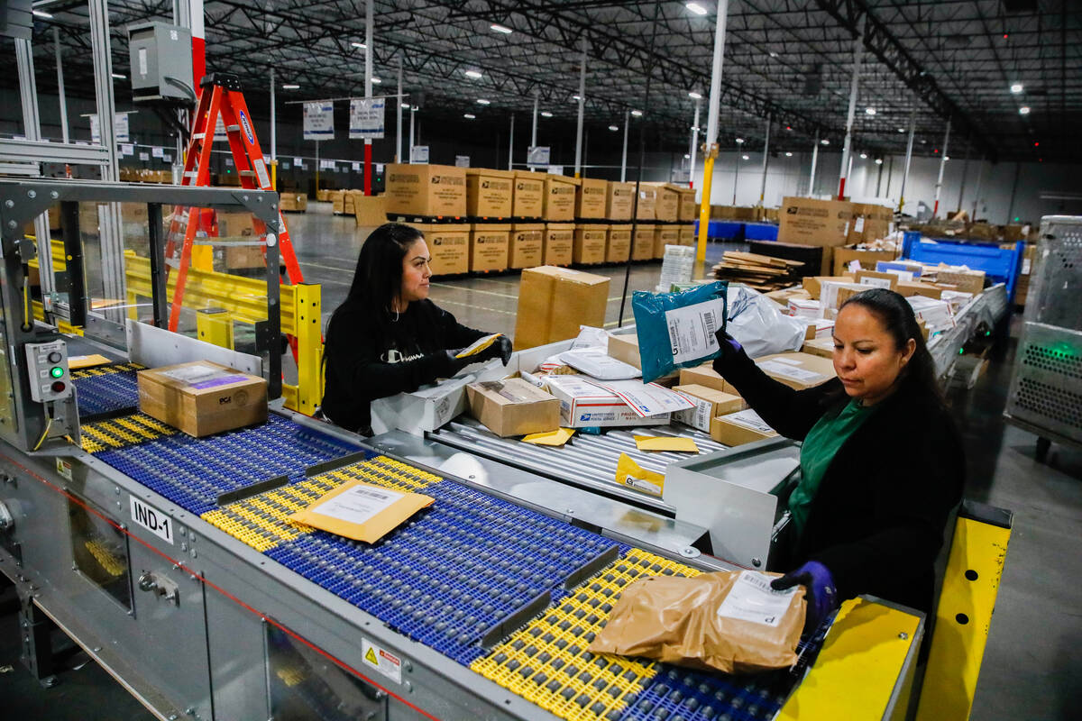 Kim Lopez, left, and Aureoia Garcia, USPS employees, sort packages at a distribution center les ...