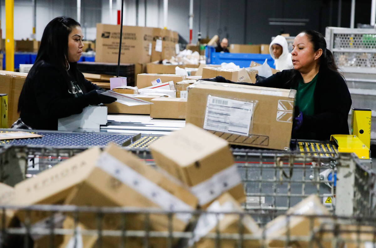 Kim Lopez, left, and Aureoia Garcia, USPS employees, sort packages at a distribution center les ...