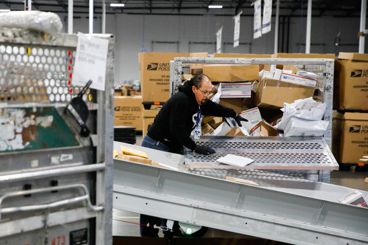 Marcos Guerra, a USPS employee, sorts packages at a distribution center less than two weeks bef ...